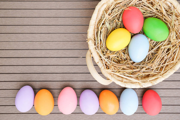 Close up Colorful easter eggs in the basket on wood background with space - Valokuva, kuva