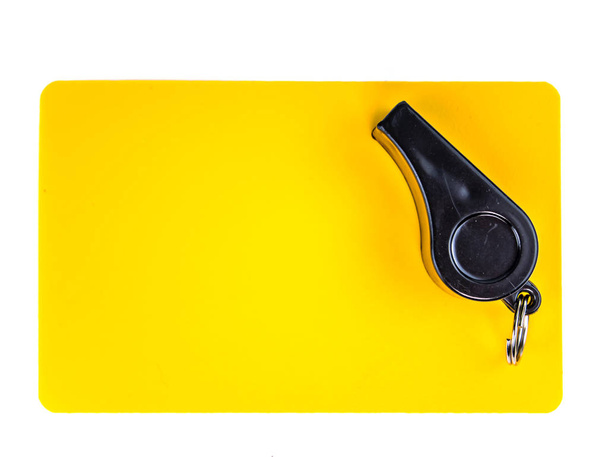 Yellow card and whistle of a football referee on a white background. - Photo, Image