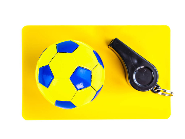 Футбольний м'яч і жовта листівка з свистом футбольного арбітра на білому тлі
. - Фото, зображення
