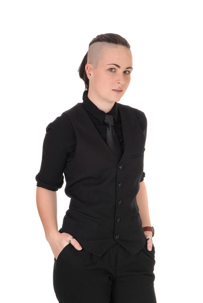 A gorgeous young woman in a black shirt and tie and a fancy haircut.standing with hands in pocket, isolated for white background. - Foto, imagen