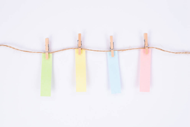 Etiqueta adhesiva colorida colgando en la cuerda aislado fondo blanco
 - Foto, Imagen