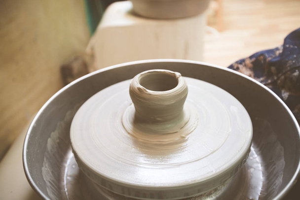 Clay bowl on pottery wheel at workshop. - Fotoğraf, Görsel
