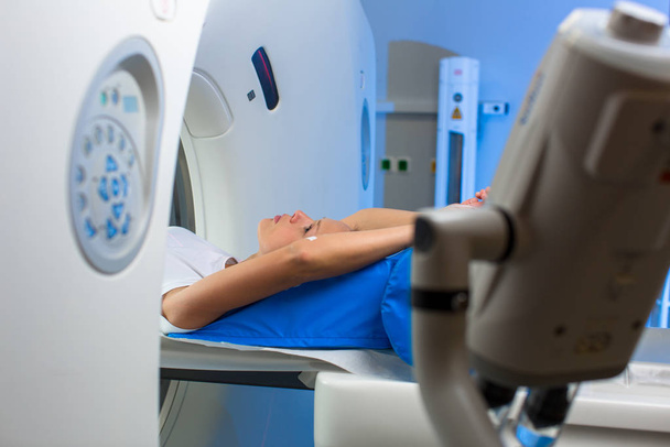Bella, giovane donna goiing attraverso una tomografia assiale computerizzata (CAT) Scansione test medico / esame in un ospedale moderno (colore tonica immagine
 - Foto, immagini