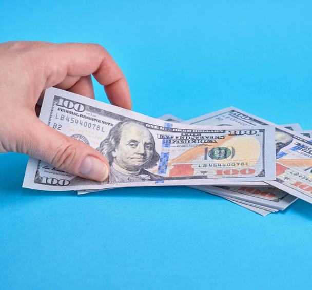 paper money and human hand on blue background, close up - Фото, изображение