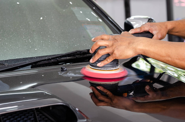 man hand cleaning the car with polishing and waxing - Fotó, kép
