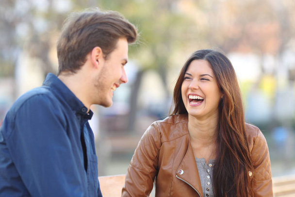 Funny couple laughing together looking each other in the street - Foto, Imagen