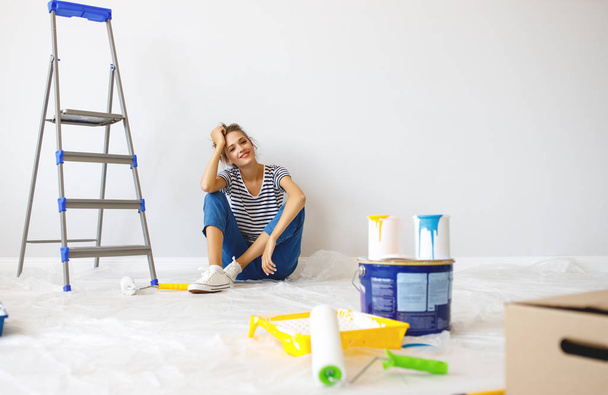 Reparatur in der Wohnung. glückliche junge Frau bemalt Wand - Foto, Bild