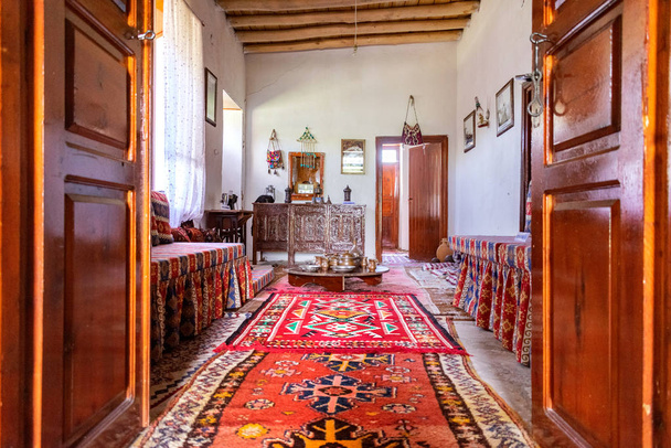 Traditional Turkish house interior with all authentic furniture and carpets on the floor. Light coming in through the side window. - Фото, зображення