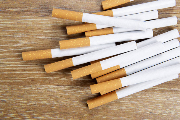 Several cigarettes on a wooden background - Fotoğraf, Görsel