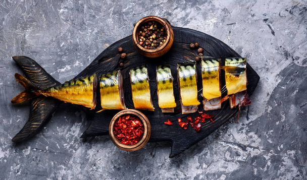 Appetizing fish on kitchen board.Smoked mackerel. - Φωτογραφία, εικόνα