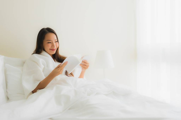 Portrait beautiful young asian women read book on bed - Фото, изображение