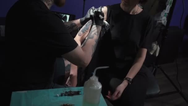 Съемки мужчины, делающего татуировку змеи для женщины в студии
 - Кадры, видео