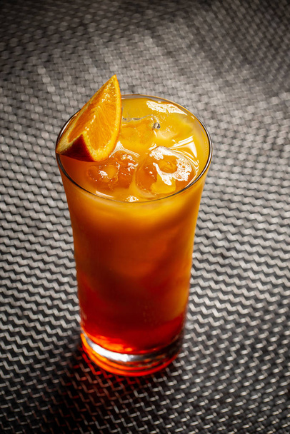 Chilled tropical aperol orange cocktail on a dark background - Fotó, kép