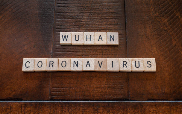 Wuhan coronavirus words made out of wooden tiles on a wooden background: health and medical concept - Фото, зображення