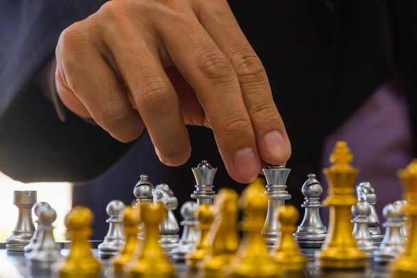 Schaken spel op schaakbord achter zakelijke man achtergrond. Bedrijfsleven - Foto, afbeelding