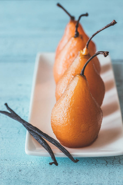 Poached pears in rose wine on the plate - Φωτογραφία, εικόνα