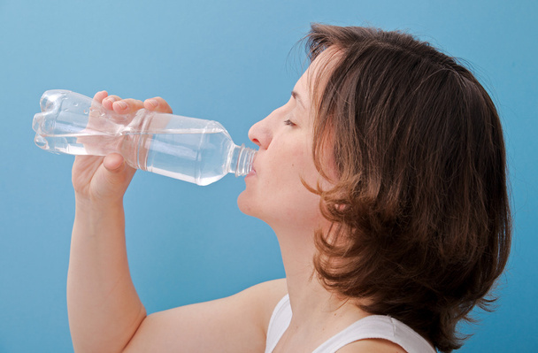 Woman drinking water from a bottle - Foto, afbeelding