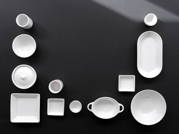 white, modern tableware in various designs on a black background, shooting in studio with daylight - Zdjęcie, obraz