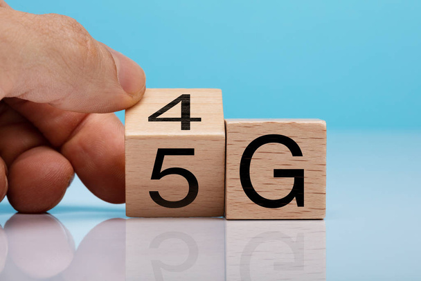 Man's Hand Changing Wooden Block From 4g To 5g On White Surface - Foto, immagini