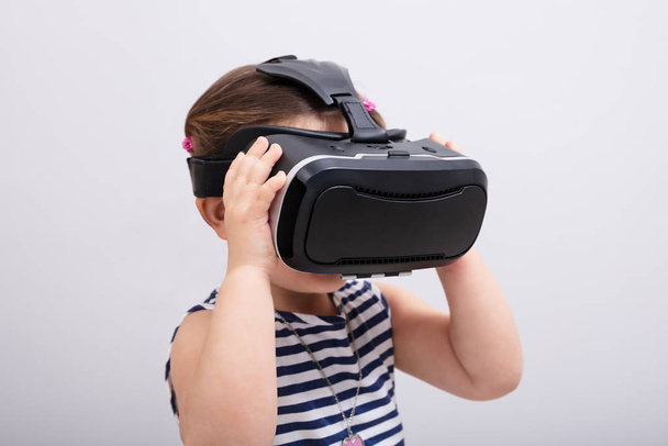 Small Girl Using The Virtual Reality Headset On White Background - Fotografie, Obrázek