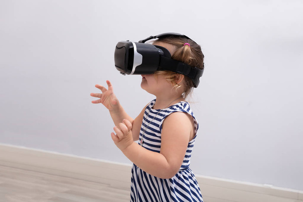 Small Girl Using The Virtual Reality Headset On White Background - Фото, изображение