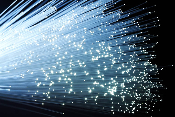 A bundle of optical fibers creates points of light in the dark. - Foto, Imagen
