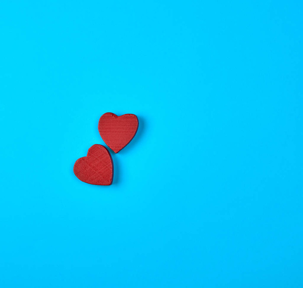 two red wooden hearts on a blue background, copy space - Foto, imagen