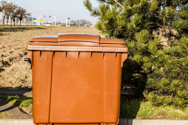 Bote de basura marrón en la calle de la ciudad
 - Foto, imagen