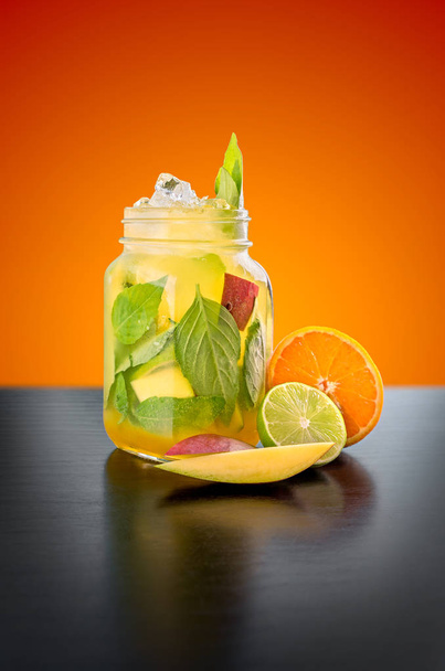 Homemade Mango and Basil Lemonade in a glass jar an orange background. - 写真・画像