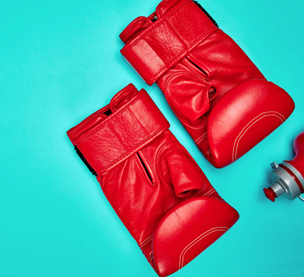 Paar rote Boxhandschuhe aus Leder auf blauem Hintergrund, Ansicht von oben - Foto, Bild
