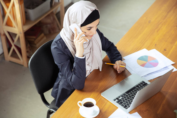 Portrait of a beautiful arabian businesswoman wearing hijab while working - Photo, image