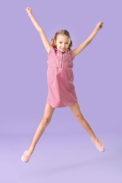 Прыжки маленькая девочка на цветном фоне - Фото, изображение