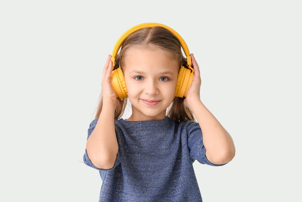 Cute little girl with headphones on white background - Photo, Image