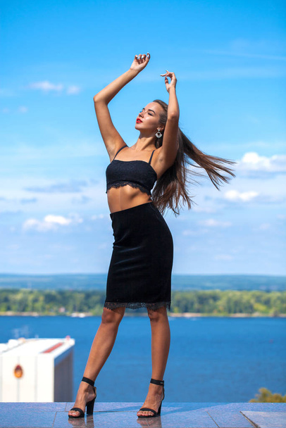 Portrait of a young beautiful girl in a black skirt and a bra po - Foto, afbeelding