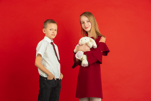 Valentines day celebration, happy caucasian kids isolated on red background - Foto, Imagen