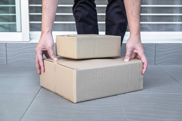 Mão do homem segurando caixas na porta da frente para receber pacote, s
 - Foto, Imagem