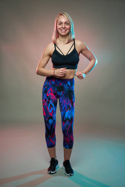 Fitness model doing aerobic exercises and dancing, studio shot - Foto, Bild