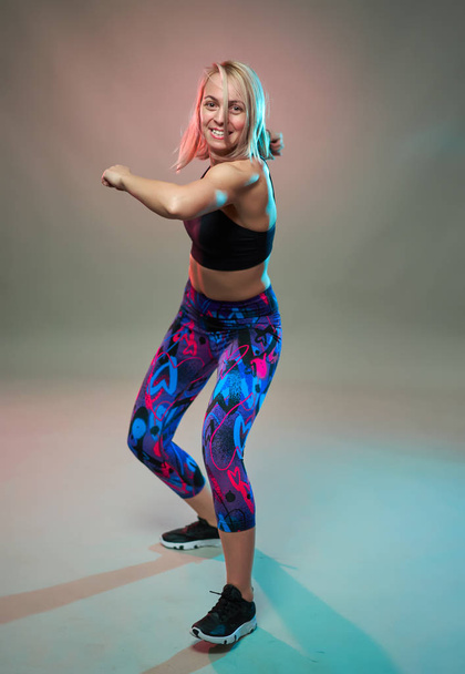 Fitness model doing aerobic exercises and dancing, studio shot - Fotografie, Obrázek
