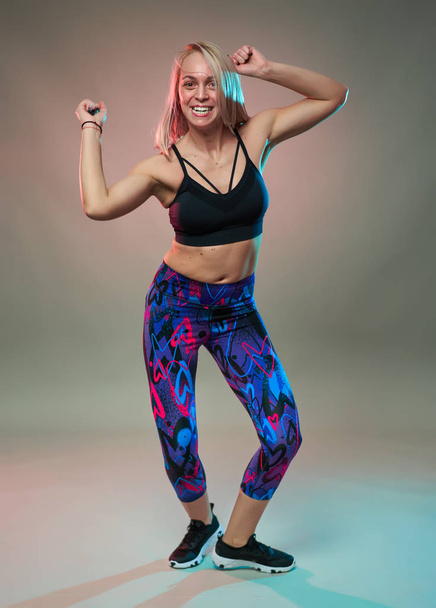 Fitness model doing aerobic exercises and dancing, studio shot - Fotoğraf, Görsel