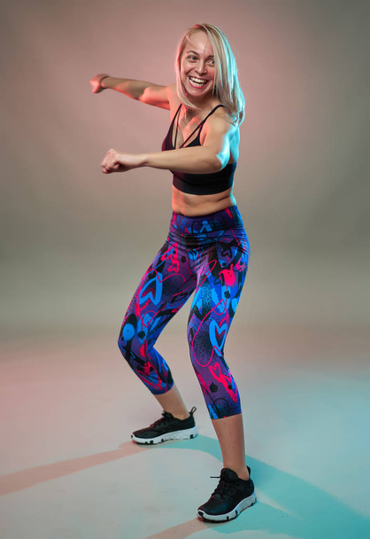Fitness model doing aerobic exercises and dancing, studio shot - Fotoğraf, Görsel