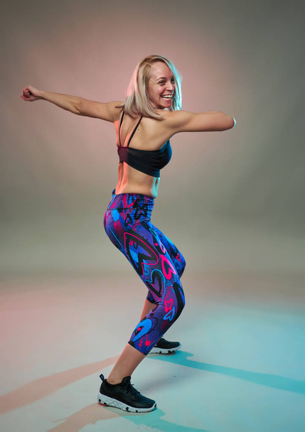 Fitness model doing aerobic exercises and dancing, studio shot - Foto, afbeelding