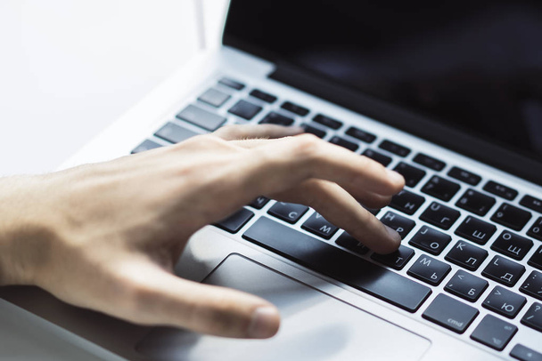 Closeup of male hand presses a button on laptop keyboard - 写真・画像