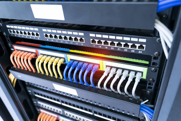 Netwerkkabel in switch en firewall in cloud computing datacenter server rack - Foto, afbeelding