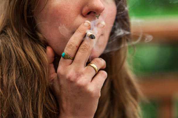 Pot αμβλύ καπνιστό από τη γυναίκα εξωτερική στη φύση - Φωτογραφία, εικόνα