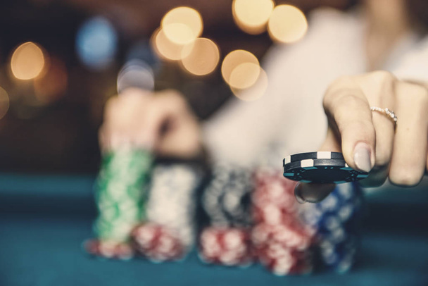 Female hand taking poker chips from pile - Fotó, kép