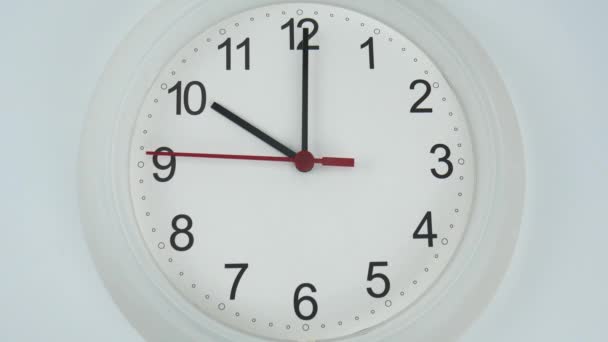 Orologio da parete bianco su sfondo bianco, faccia inizio tempo 10.00 am o pm, Orologio minuto a piedi lentamente, concetto di tempo. - Filmati, video