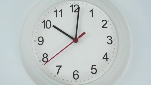 Cierre del reloj de pared blanca frente al comienzo del tiempo 10.01 am o pm. sobre fondo blanco, concepto de tiempo. - Metraje, vídeo