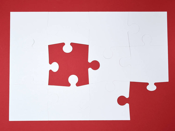 white large blank puzzles on a red background, top view - Foto, imagen