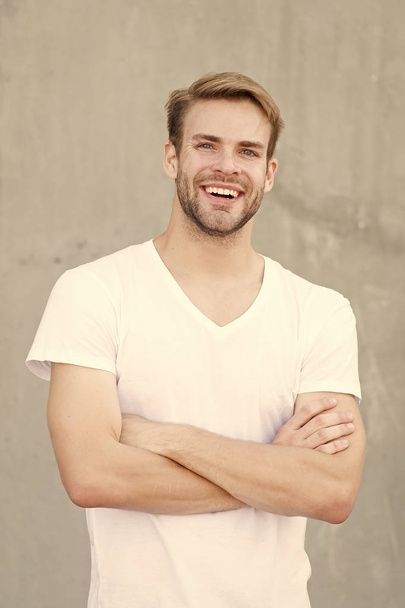 Ideal traits that make man physically attractive. Bearded guy casual style close up. Charming smile. Male beauty standards. Handsome man stylish hairstyle. Handsome caucasian man gray background - Photo, Image