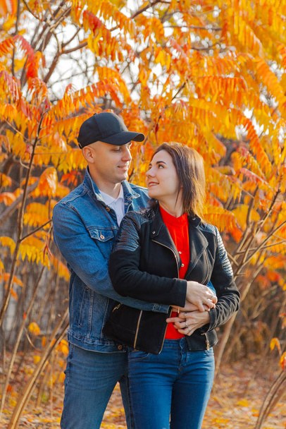 Ευτυχισμένο ζευγάρι ερωτευμένο σε φόντο κίτρινα φύλλα το φθινόπωρο. - Φωτογραφία, εικόνα